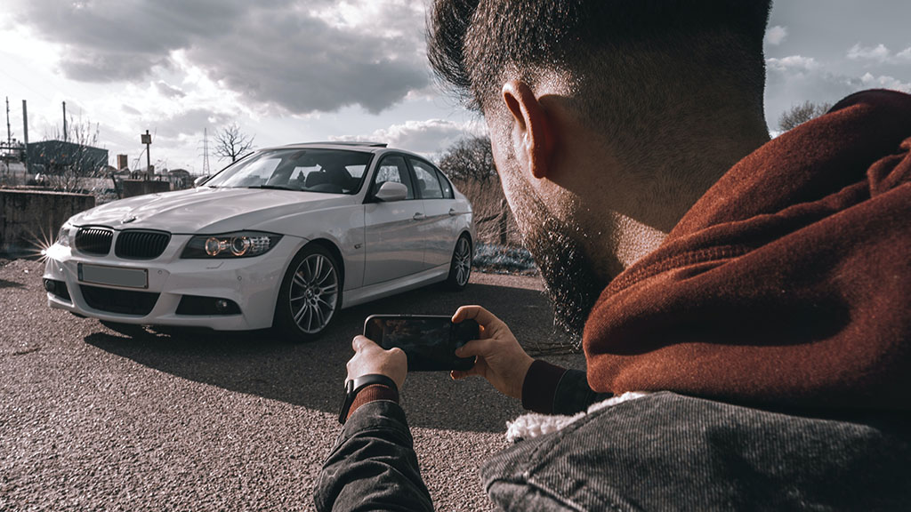 Person taking photo of car